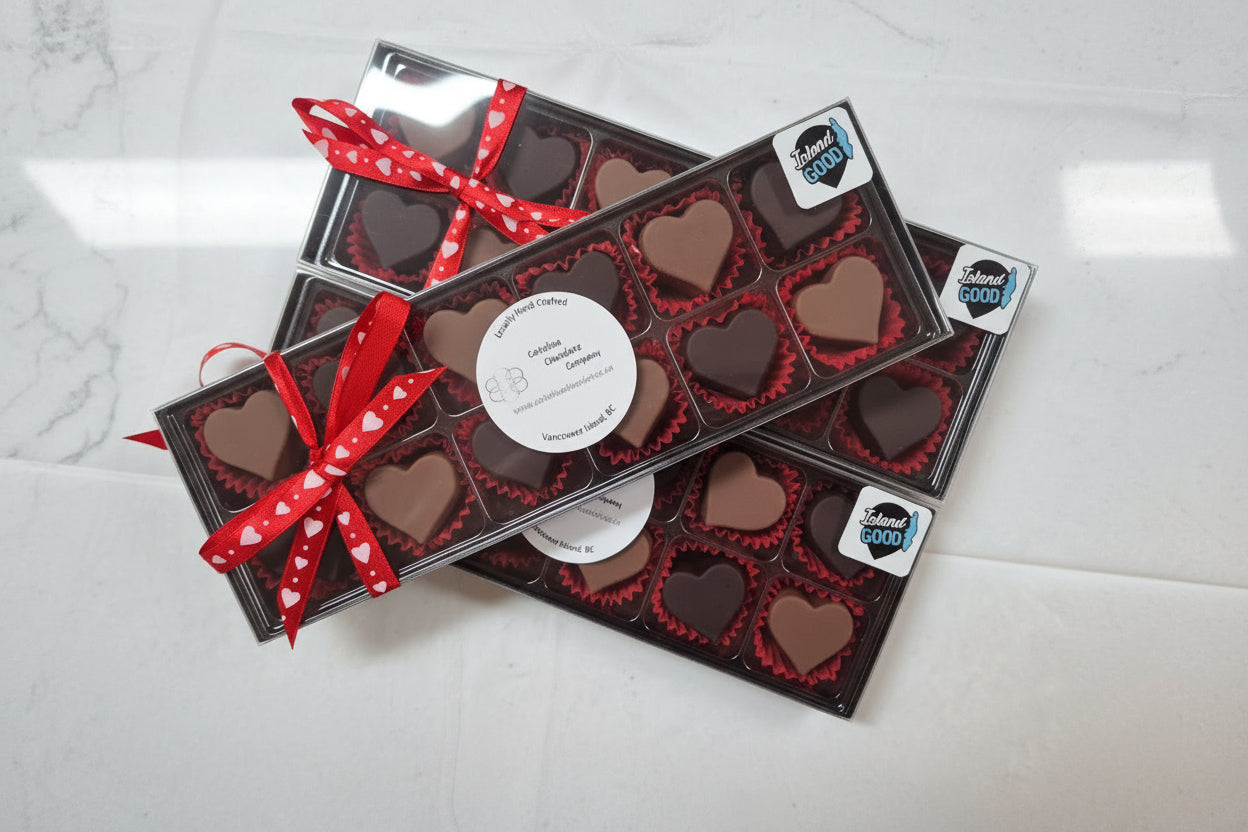 Multiple boxes of heart-shaped chocolates with a red ribbon on a light gray background. Vancouver Island