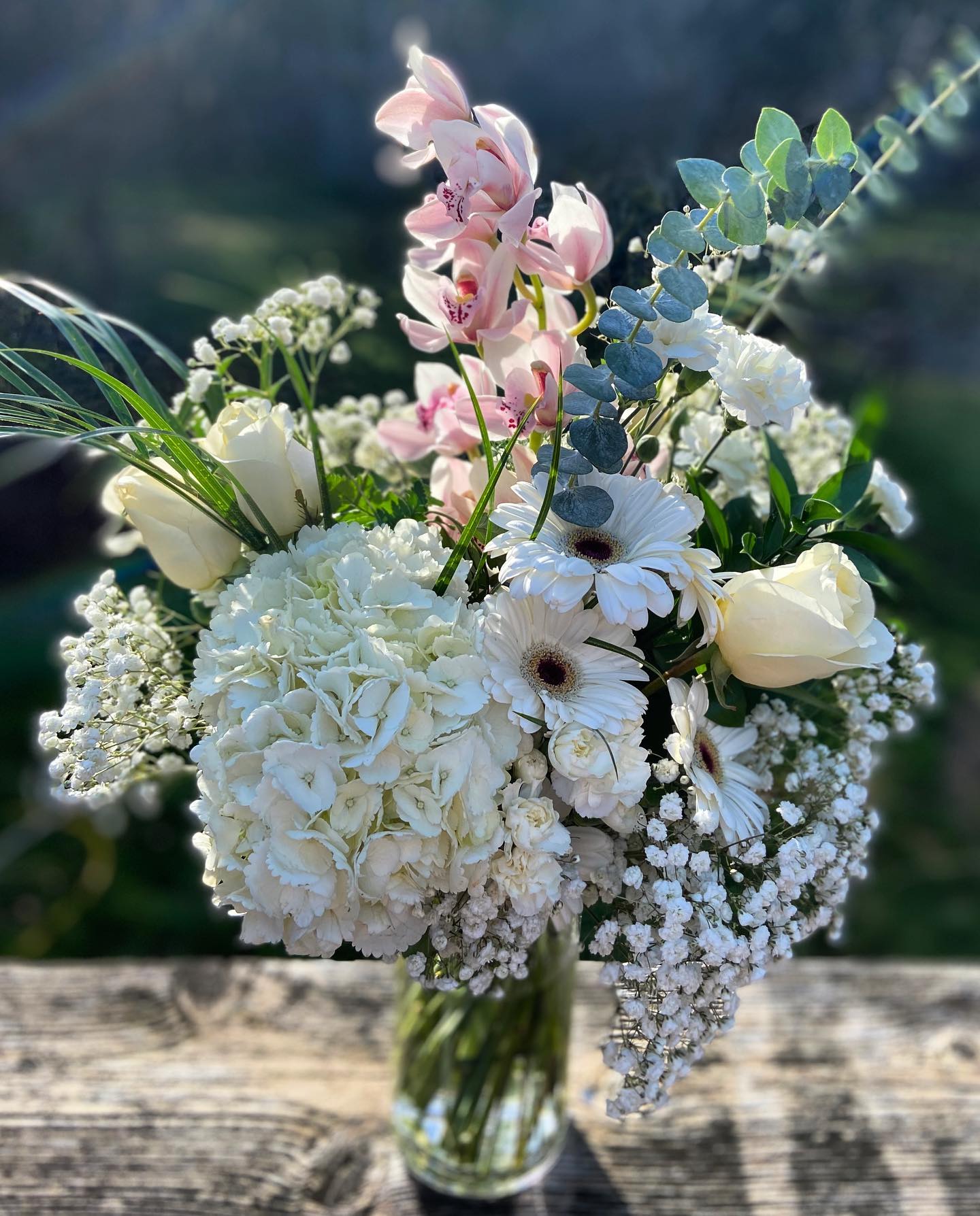 White and pink flower arrangement with eucalyptus.
