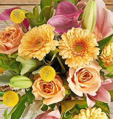 Yellow gerberas and roses with craspedia and lilies.