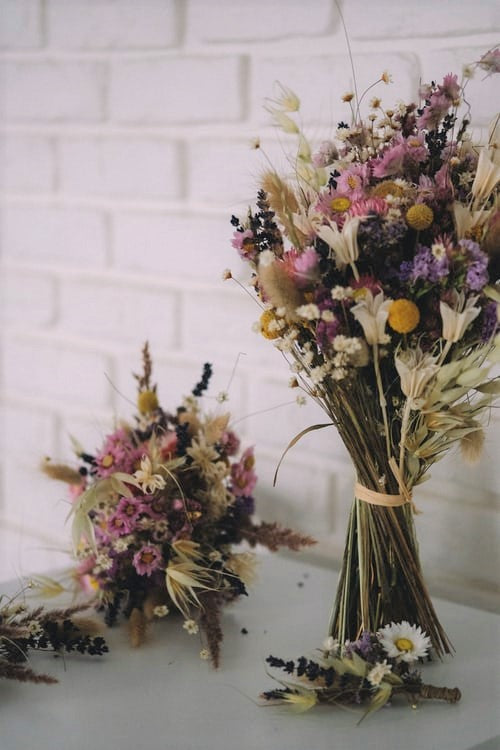 Two dried flower bouquets with a raffia tie.