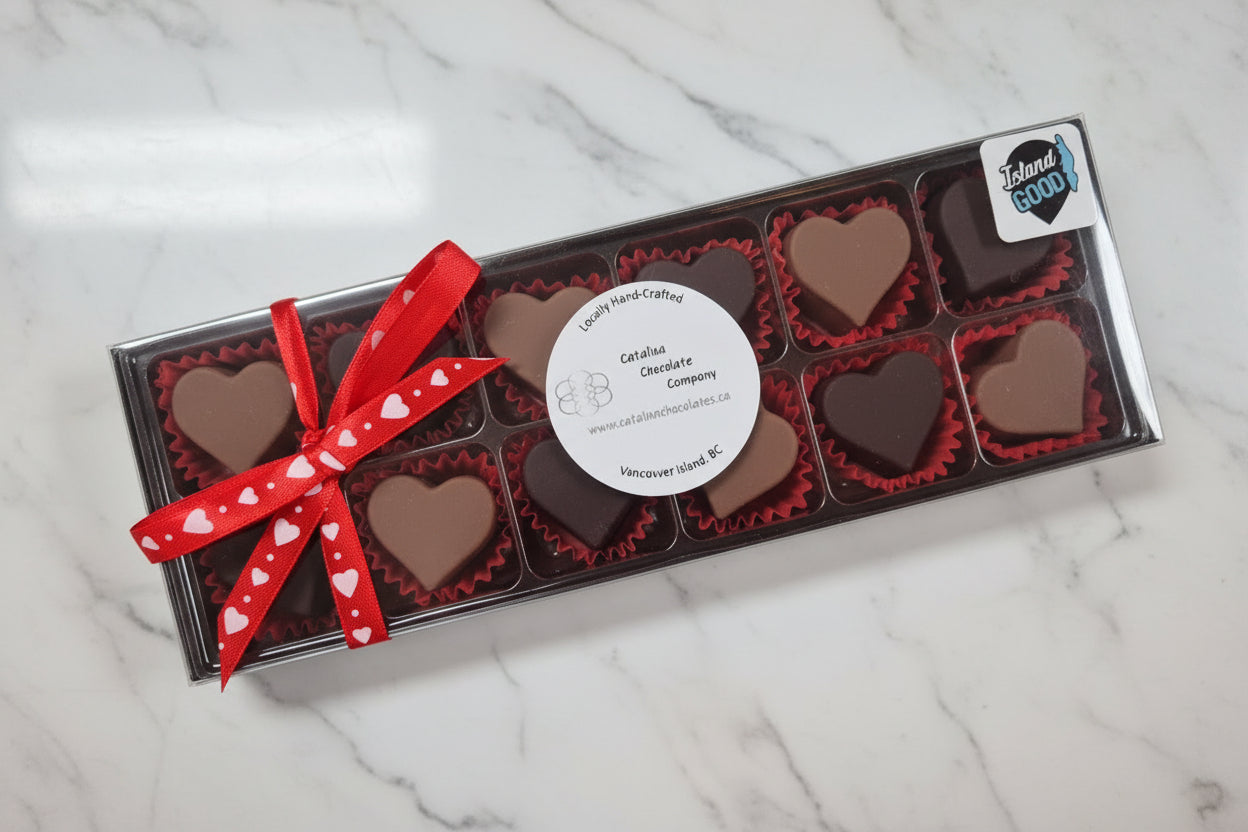 Box of heart-shaped chocolates with a red ribbon on a light gray background. Vancouver Island