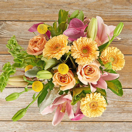 Yellow gerberas, roses, lilies, craspedia and pink flower bouquet.