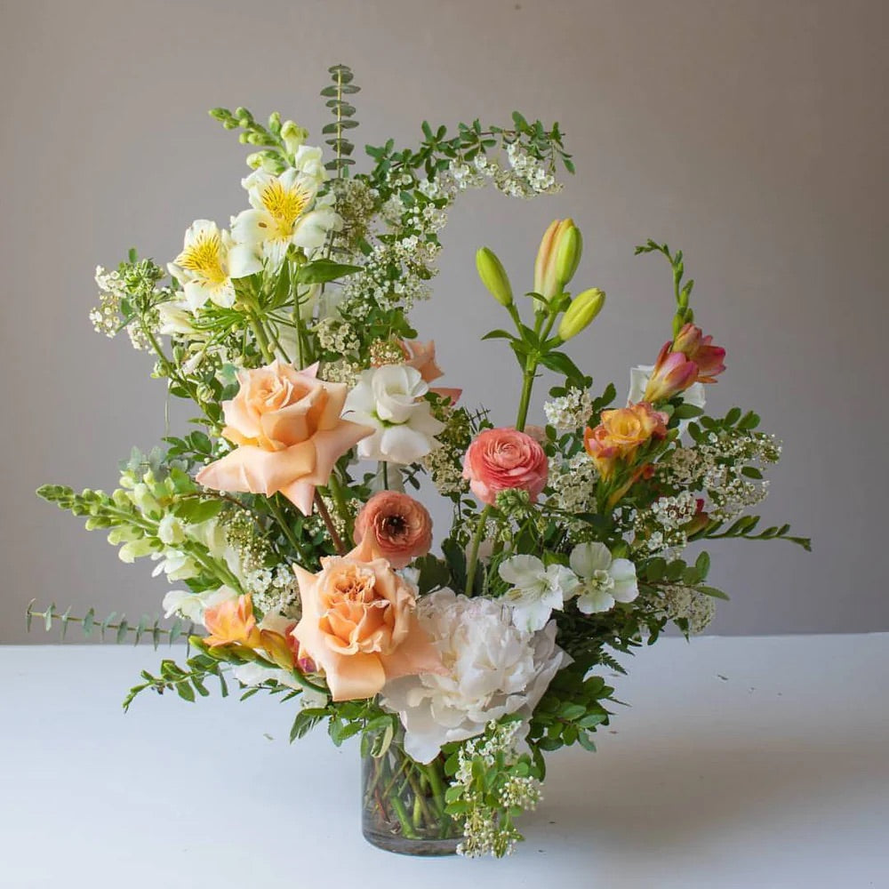 Cream, pink and white flower arrangement in a vase. 