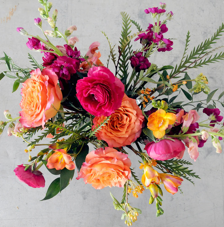 Fun colourful bouquet with bright pink, orange, fuchsia, and yellow flowers.  