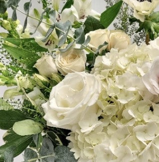 White hydrangeas, lisianthus and white roses with greenery.